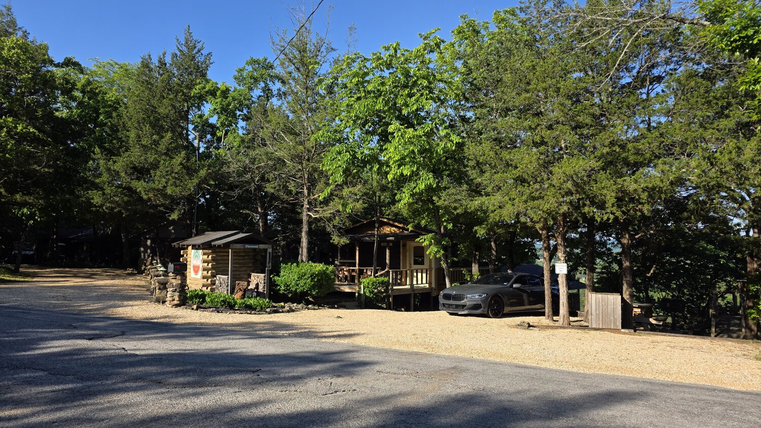 Log cabins and gravel drive set among the trees on the property