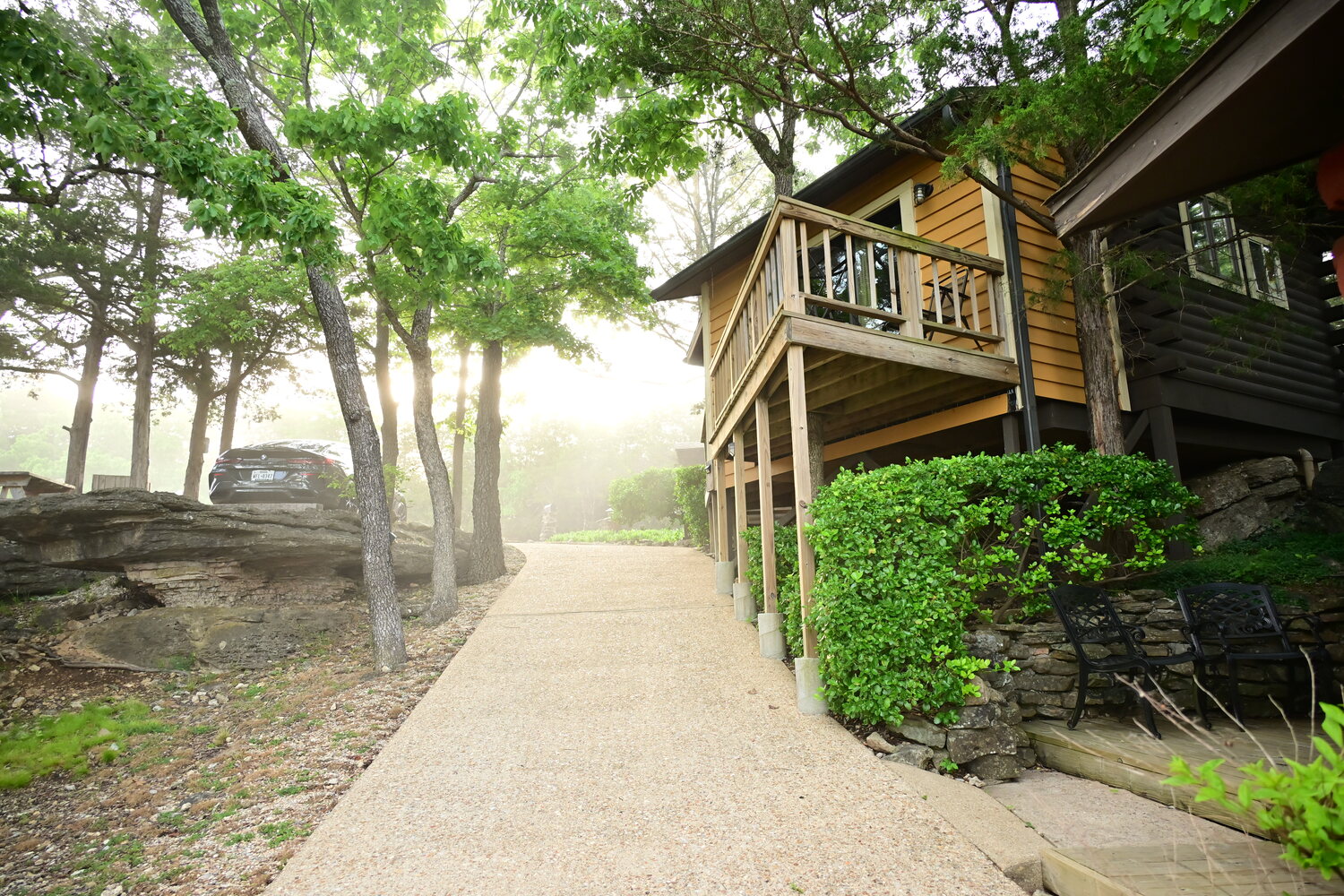 Stone-lined path winding between the cabins through the misty morning grounds