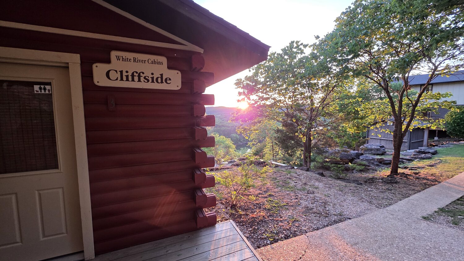 The Cliffside cabin with its carved wooden name sign in evening light